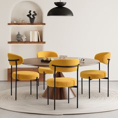 a round table with four yellow chairs and a black lamp hanging above it in a white room