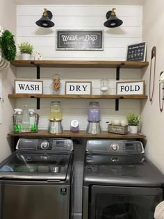 a washer and dryer in a small room with shelves above them that have signs on the wall