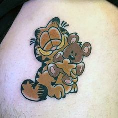 a man with a tattoo on his stomach holding a teddy bear