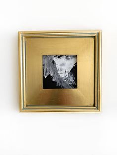 a black and white photo in a gold frame