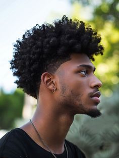 This sleek version of the Curly Afro Fade is designed for the sophisticated man who attends cocktail parties or enjoys an upscale nightlife. The sharp, clean lines around the forehead and temples create a striking contrast with the soft curls on top. This style is particularly flattering for square and diamond face shapes, as it softens the jawline while enhancing facial symmetry. 4c Curly Hairstyles Men, Afro Hawk Hairstyles, Sponge Hairstyles For Men, 4b Hairstyles Men, Black Guy Hairstyles Short, Frosted Tips Hair Men Curly, Burst Fade Black Men, Afro Haircut Men