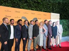 a group of people standing next to each other on a red carpet