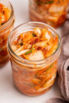 three jars filled with food sitting on top of a table