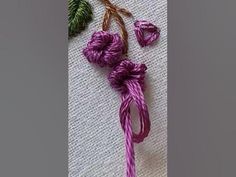 some purple yarn and green leaves on a table