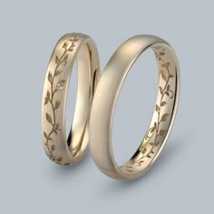 two gold wedding bands with leaves and diamonds on the inside, set in 18k yellow gold