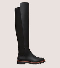 The over-the-knee ADRINA CITY BOOT is precisely crafted for a sleek and comfortable fit to the calf. It is defined by a flexible back, which is paired with a contrasting leather front. This design is set on a lug sole that lends modern edge to the look while simultaneously delivering a subtle, wearable lift.​ Flexible Back, Lug Sole, Over The Knee, Stuart Weitzman, Smooth Leather, Block Heels, Heel Height, Comfort Fit, Sleek