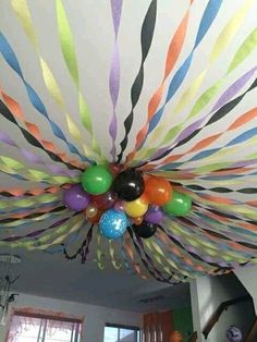 a ceiling decorated with balloons and streamers in the shape of a sunburst