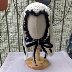 a crocheted hat on top of a wooden stand