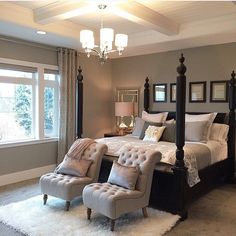 a bedroom with four poster bed, two chairs and a chandelier hanging from the ceiling