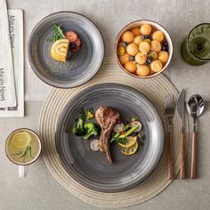 a table topped with plates and bowls filled with different types of food next to utensils