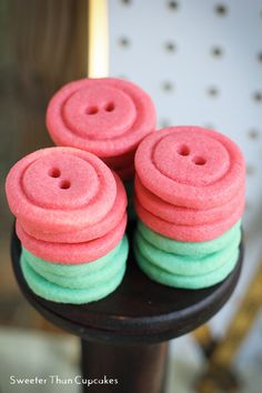 some pink and green cookies are stacked on top of each other in the shape of buttons