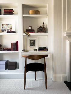 a desk and chair in a room with white walls