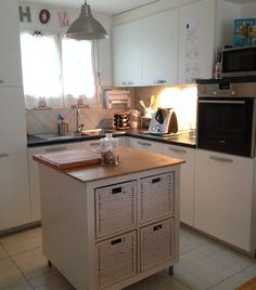 a kitchen with white cabinets and wooden counter tops