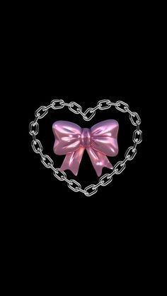 a pink bow is attached to a chain in the shape of a heart on a black background