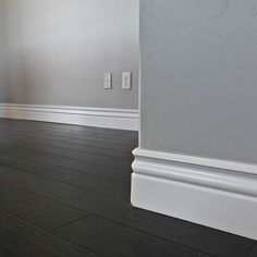 an empty room with gray walls and white trim