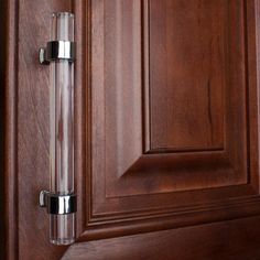 a close up of a door handle on a wooden cabinet with wood grained doors