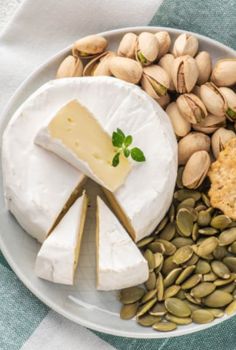 a plate with cheese, crackers and nuts on it