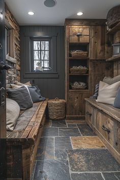 a room with stone flooring and wooden shelves filled with pillows on top of them