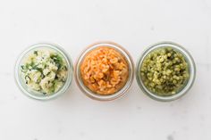 three jars filled with different types of food on top of a white counter next to each other