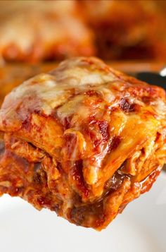 a piece of lasagna being lifted from a white plate