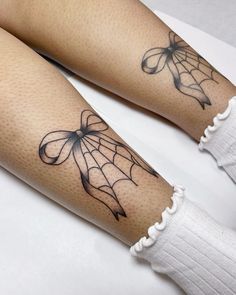 two legs with spider web tattoos on them