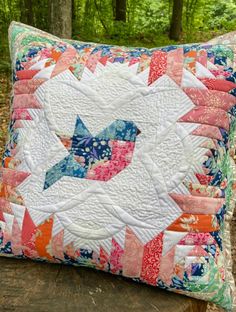 a quilted pillow sitting on top of a tree stump