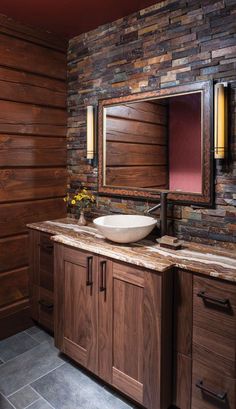 a bathroom with wooden cabinets and a stone wall