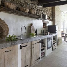 a kitchen with wooden cabinets and stone walls