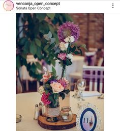 an image of a table setting with flowers in vases on the center piece and place card holders