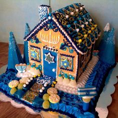 a gingerbread house decorated with blue icing and decorations