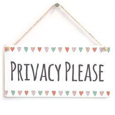 a sign that says privacy please hanging from a rope with hearts on the front and back