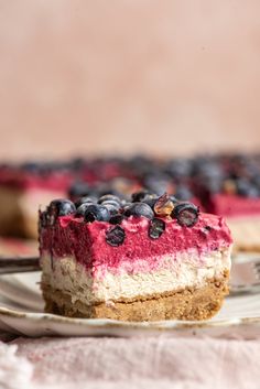 a slice of cheesecake with blueberries and almonds on top is sitting on a plate