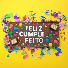 a sign that says feliz cumple feito surrounded by confetti and sprinkles