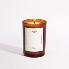 an apple candle sitting on top of a white table