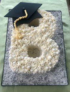 a graduation cap and diploma on top of a cake with white frosting spirals