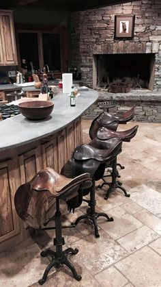 several chairs are lined up in front of an island with a stone fireplace behind it