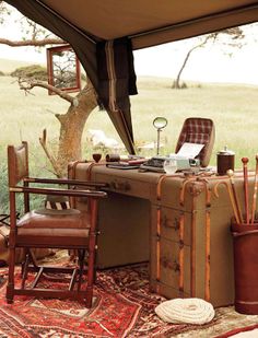 an old suitcase sitting on top of a rug in front of a desk and chair