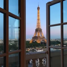 the eiffel tower is seen through an open window