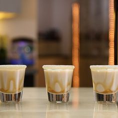 three shot glasses sitting on top of a counter