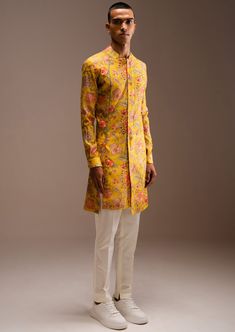 The yellow hamdard long kurta pajama set includes a yellow printed kurta with a cream cotton pajama. This is a two-piece set. This kurta has a shawl collar and concealed placket detail. A crochet lace detail runs from the collar down to create a slit. The kurta is complete with a staggered hemline and cuffed sleeves. It is constructed with lightweight chanderi fabric, and the all-over jaal print is from our archives. The trouser style pajama features an elasticated back, zip and fly front closure, and two hip pockets. The pajama is cut to a slim fit and has ankle slits for ease of wear. Haldi Outfits, Long Kurta, Kurta Pajama, Nehru Jackets, Trouser Style, Yellow Print, Wedding Service, Cotton Pyjamas, Bride Bridal