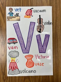 a poster with the letter v in different colors and words written below it on a wooden surface