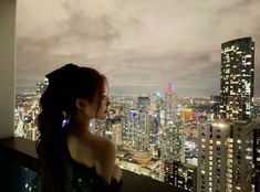 a woman looking out over the city at night