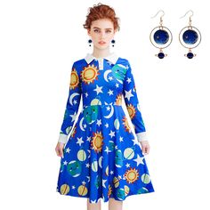 a woman wearing a blue dress with sun, moon and stars on the front is standing next to a pair of earrings