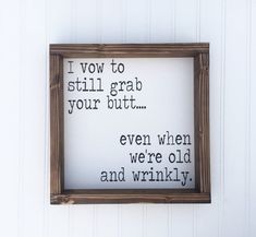 a wooden frame hanging on the side of a white wall with words written in it