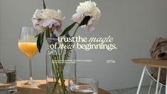 flowers in a vase on a table next to two glasses and a bottle of wine