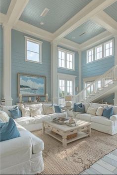 a living room filled with white furniture and blue walls