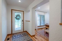 an entry way with a door and rug on the floor