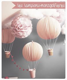 three pink paper lanterns floating in the air