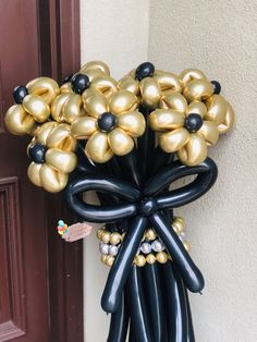 a bunch of balloons that are in the shape of a bow hanging on a door