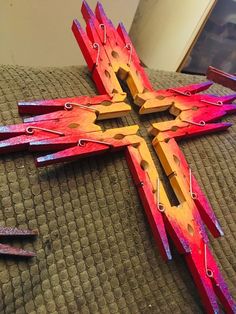 a wooden cross sitting on top of a bed next to nails and plywood sticks